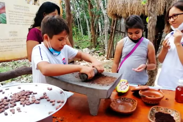 Niños moliendo cacao en metate como los antiguos mayas