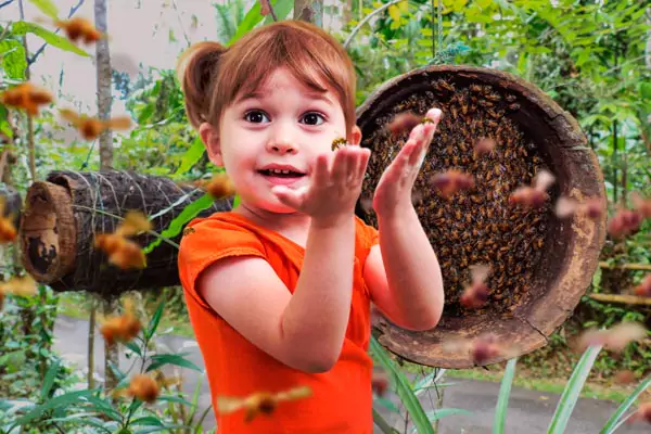 niña rubia jugando con abejas