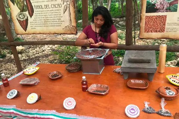 Mujer maya moliendo cacao