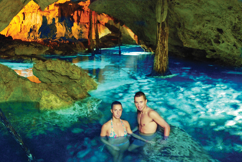 Pareja joven refrescandose en cenote subterraneo de Tulum