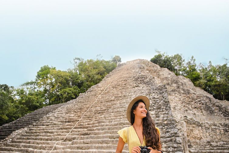 mujer joven con vestido amarillo tomando fotos en coba