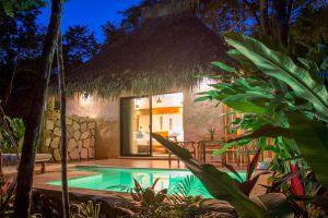 Vista nocturna de piscina en hostal de Tulum