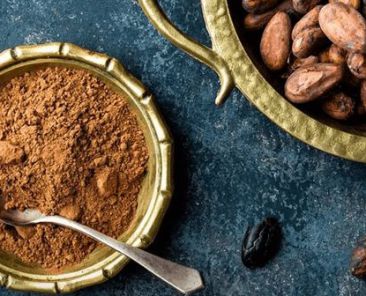 vista superior de un bowl de madera con cacao en polvo y granos de cacao natural