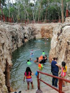 niños nadando con chaleco salvavidas en cenote koleeb caab