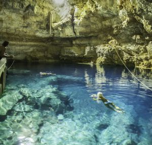 turista nadando en cenote